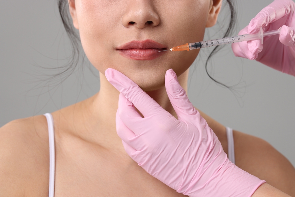 Woman,Getting,Lip,Injection,On,Grey,Background,,Closeup