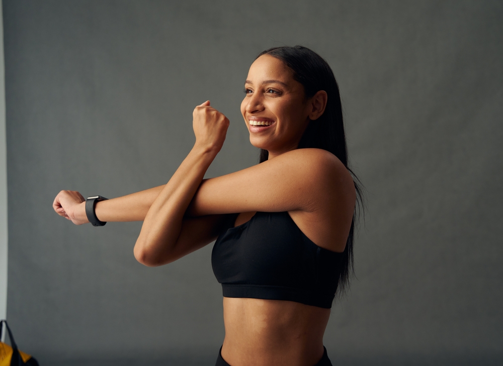 Happy,Young,Biracial,Woman,In,Sports,Bra,Doing,Cross,Arm